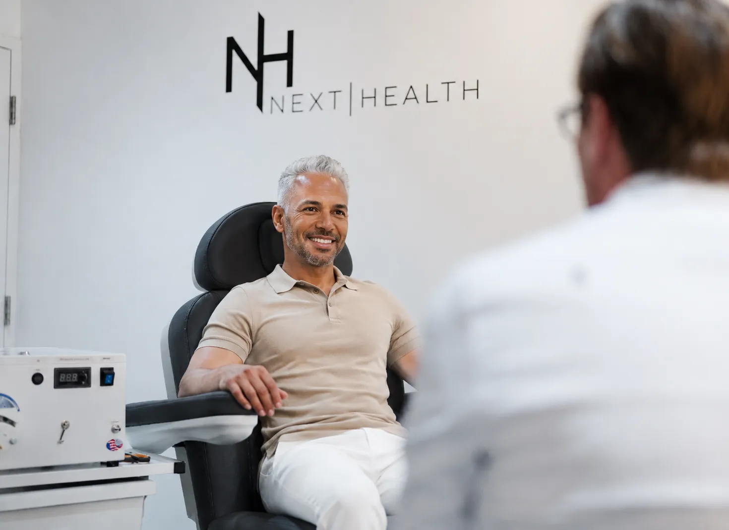 Smiling patient consulting with a Next Health provider in a treatment chair