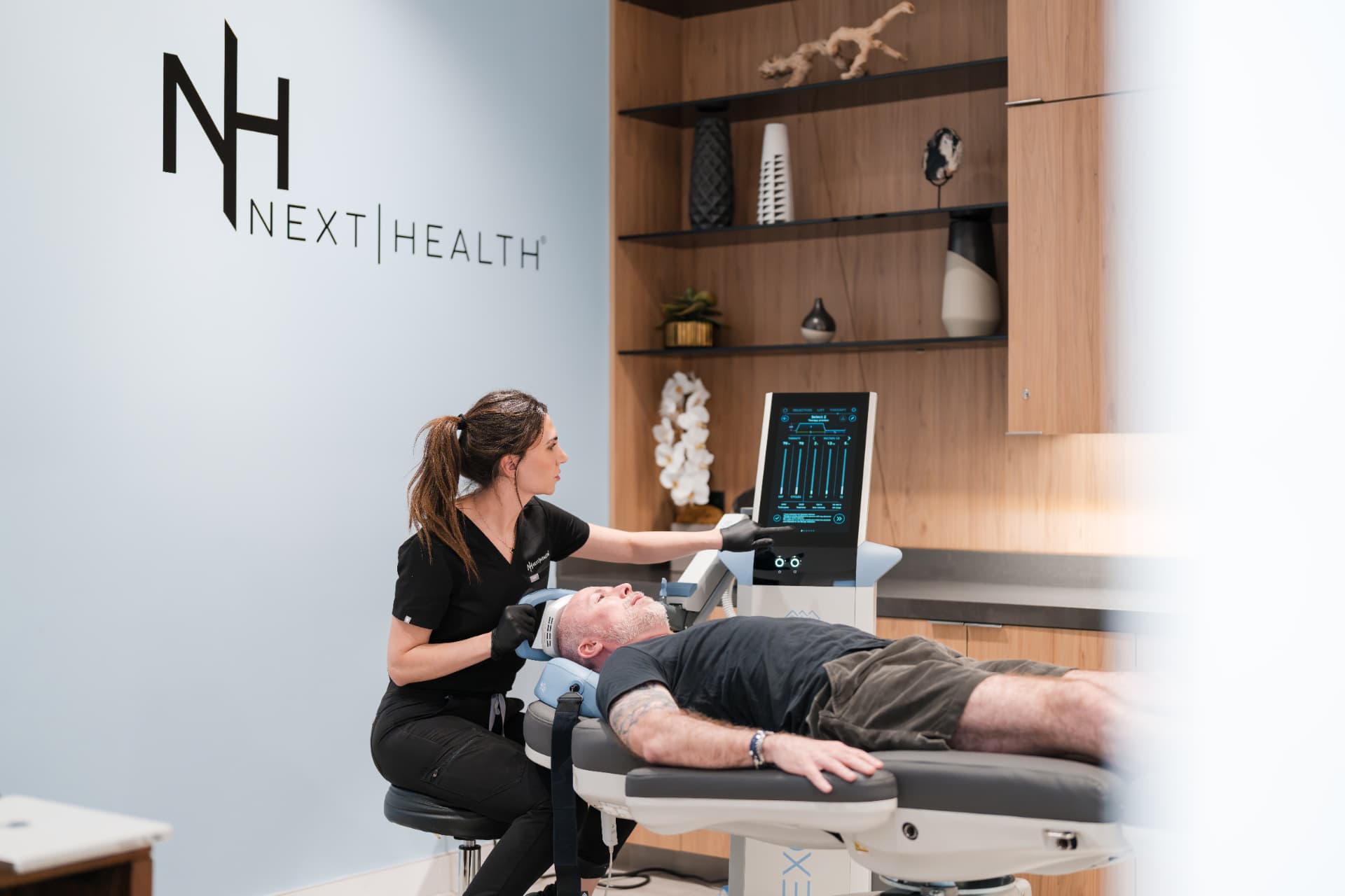 Next Health clinician adjusting an ExoMind session for a male patient
